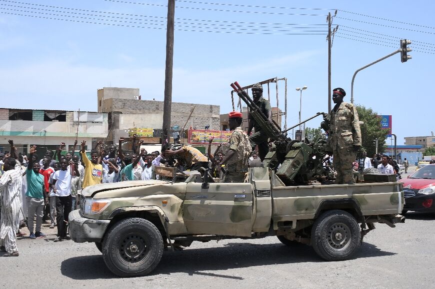 Sudanese greet army soldiers, loyal to army chief Abdel Fattah al-Burhan, in the Red Sea city of Port Sudan 