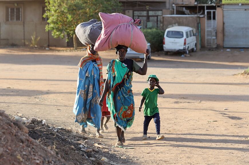 People flee their neighbourhoods amid fighting between the army and paramilitaries in Khartoum on April 19 