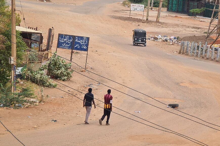 People walk on a deserted street in Khartoum 
