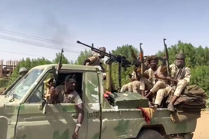 In this image grab taken from handout video footage released by the Sudanese paramilitary Rapid Support Forces (RSF) on April 23, 2023, fighters ride in the back of an armed pickup