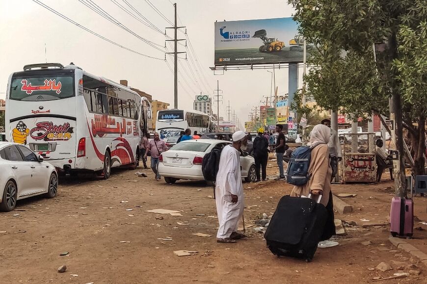 Sudanese civlians desperate to escape the fighting in the capital Khartoum prepare to board a bus out