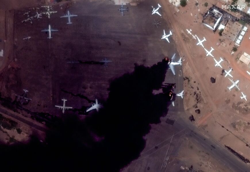 A satellite image shows two Il-76 transport aircraft on fire and several additional planes damaged at Khartoum International Airport


