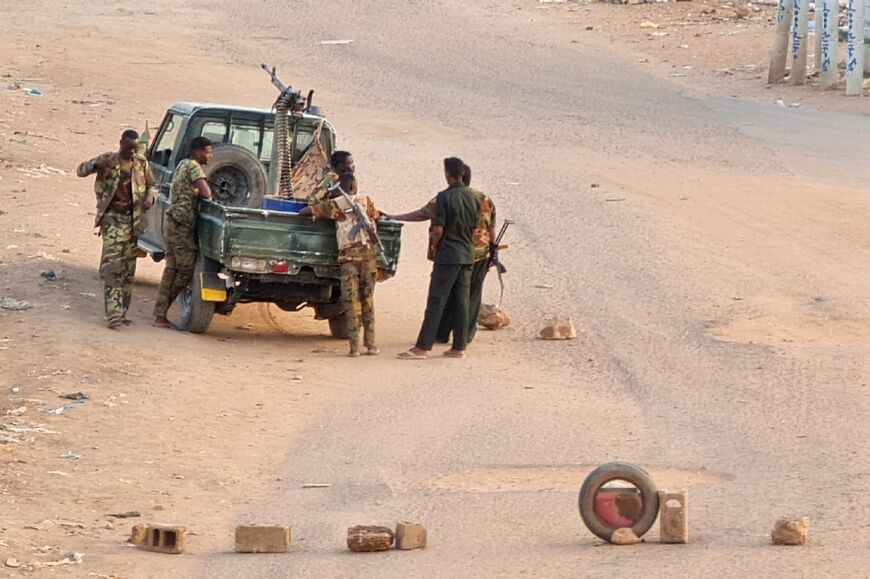 Soldiers of the Sudanese army on a road blocked with bricks in Khartoum on May 20, 2023