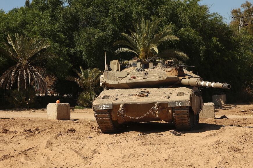 An Israeli tank takes an artillery position near the southern city of Sderot near the border with Gaza