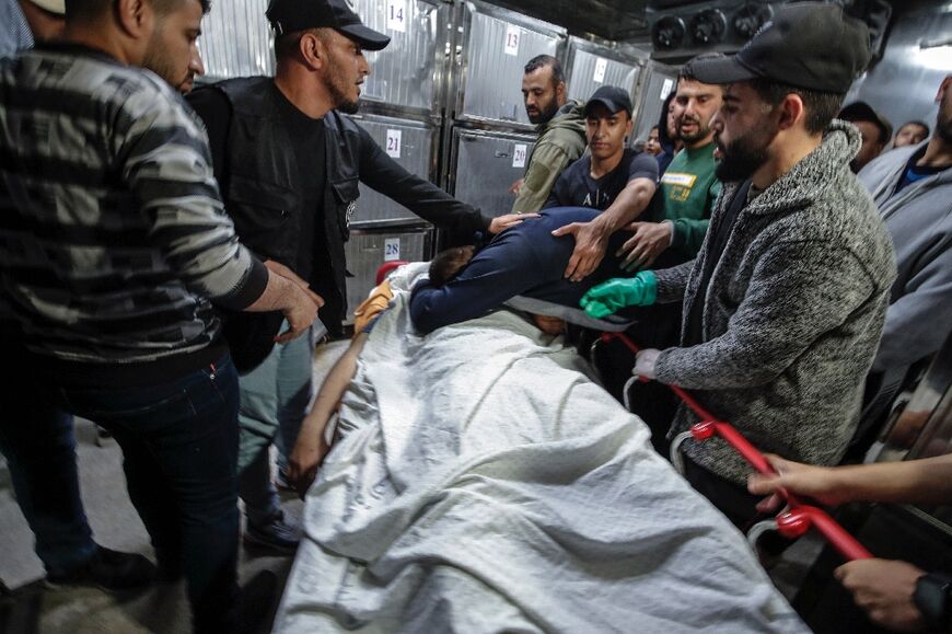 Relatives of the Palestinian Islamic Jihad leader Khalil Bahtini mourn next to his body