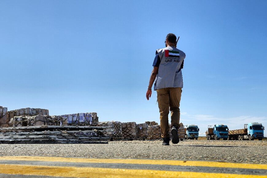 A worker in Port Sudan coordinates the unloading of aid supplies from an Emirati aircraft
