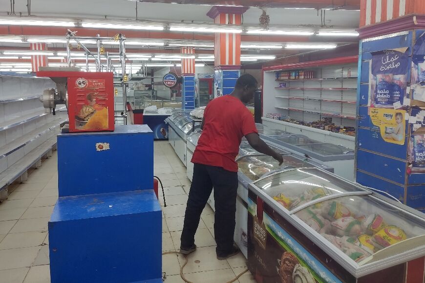A man walks past empty shelves at a supermarket in Khartoum on May 18