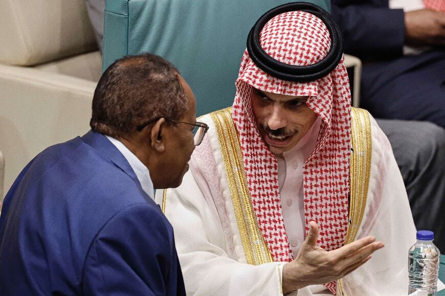 Saudi Arabia's Foreign Minister Prince Faisal bin Farhan (R) speaks with Sudan's ambassador to Egypt Abdelaziz Hassan Saleh during an emergency meeting of Arab League foreign ministers in Cairo 