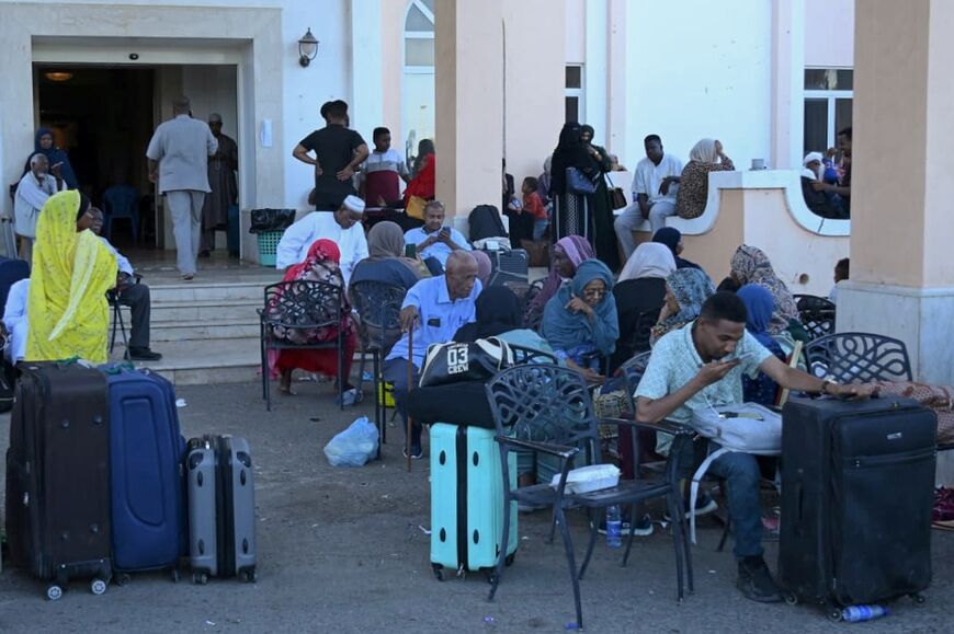 People wait with their luggage at Port Sudan ahead of their evacuation by sea 