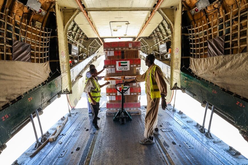 Workers offload WHO and UAEAID aid supplies from a plane in Port Sudan