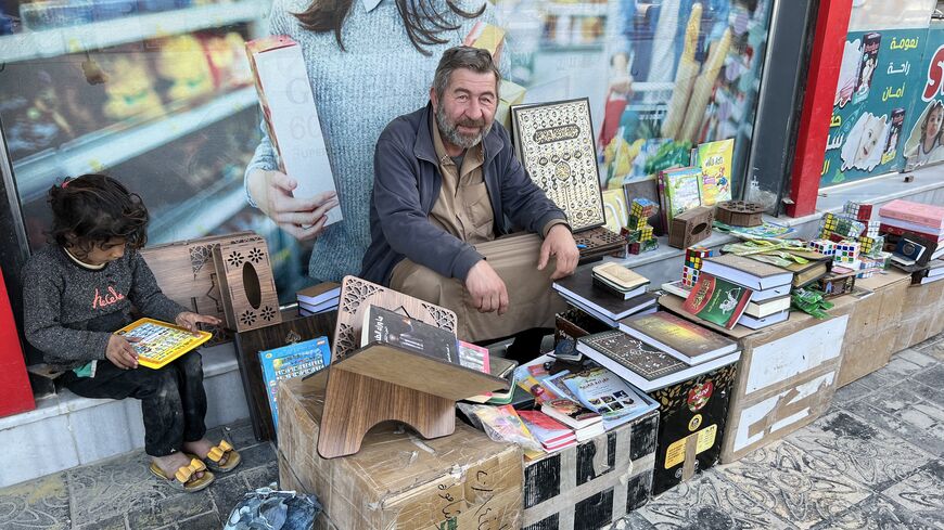 A man selling religious books on a sidewalk in central Rawls, April 25, 2023. (Amberin Zaman/Al-Monitor)