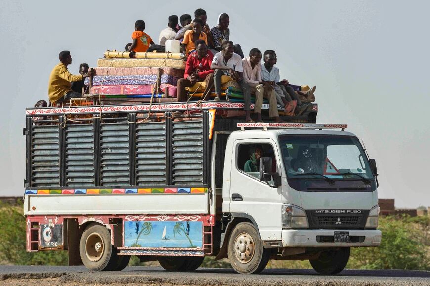 Fleeing Khartoum residents crowd onto a truck crammed with their belongings