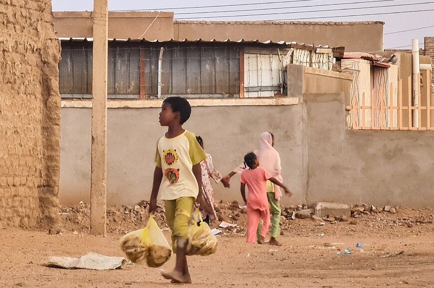 A child carries bread in Khartoum, where the war has broad shortages of essential goods