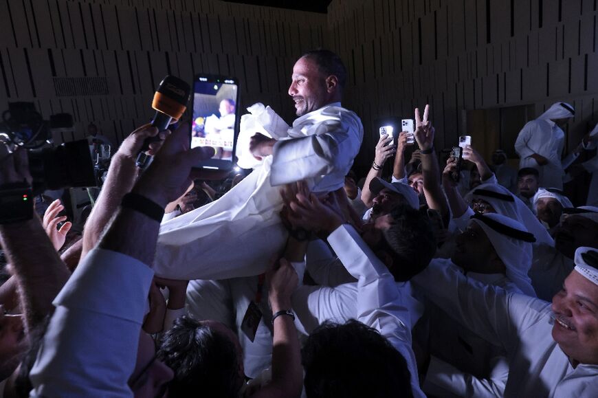 Kuwait's former parliament speaker Marzouq al-Ghanim celebrates with supporters after he retains his seat in a general election that returned an opposition majority
