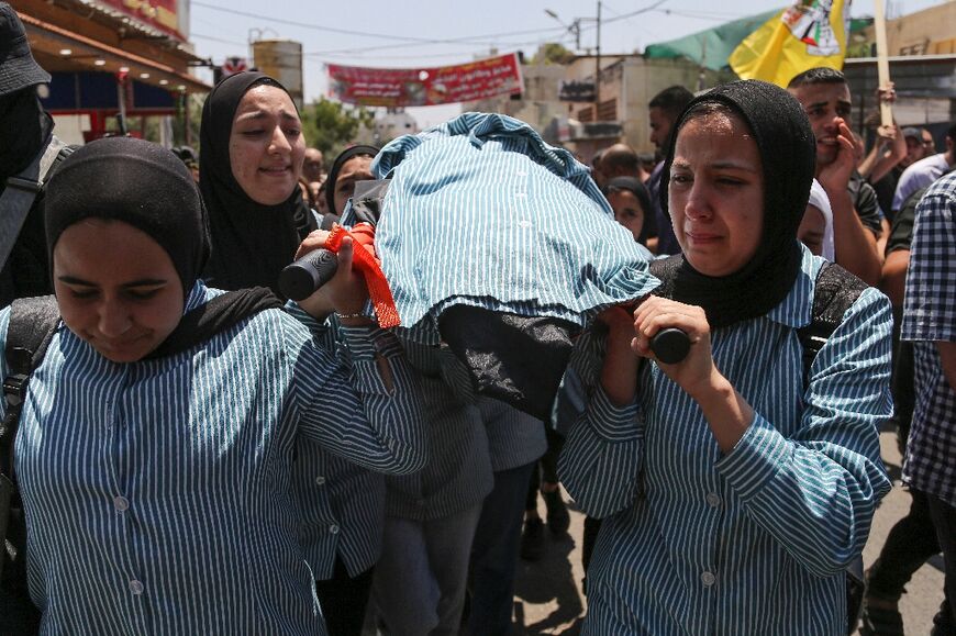 Palestinian schoolgirls mourn their 15-year-old classmate Sadil Naghnaghiya, in Jenin in the occupied West Bank
