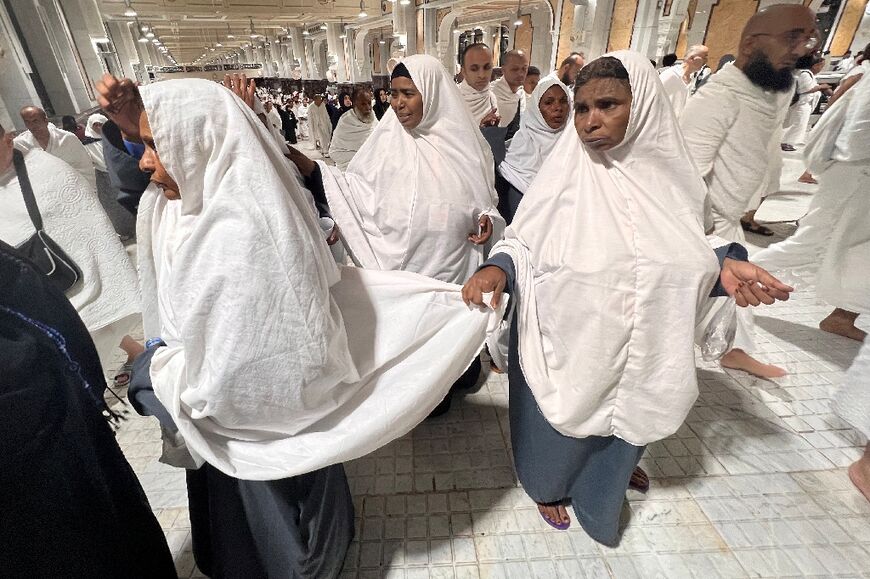 Sudanese pilgrims in Mecca walk in groups, their country's flag printed on their white robes