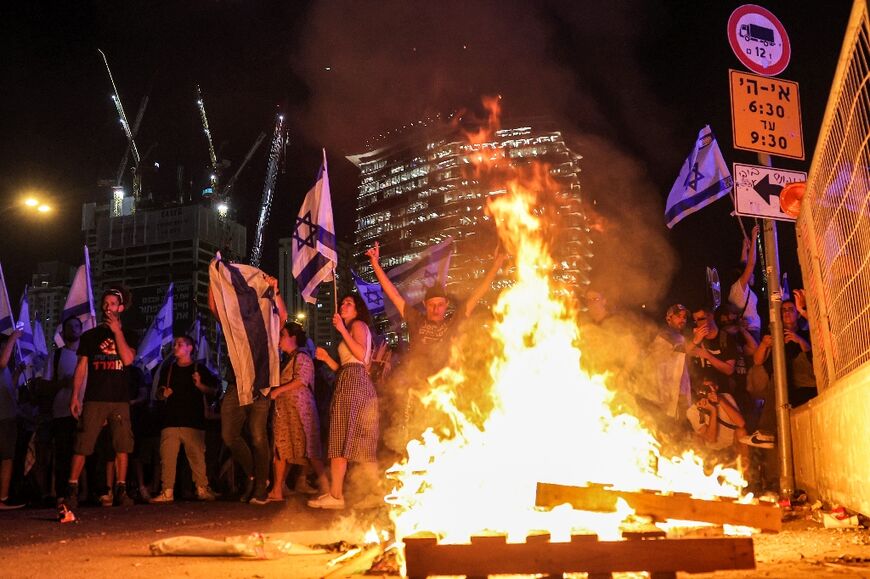 Demonstrators gather before a bonfire in Tel Aviv hours after parliament voted for a key clause of the government's judicial reforms