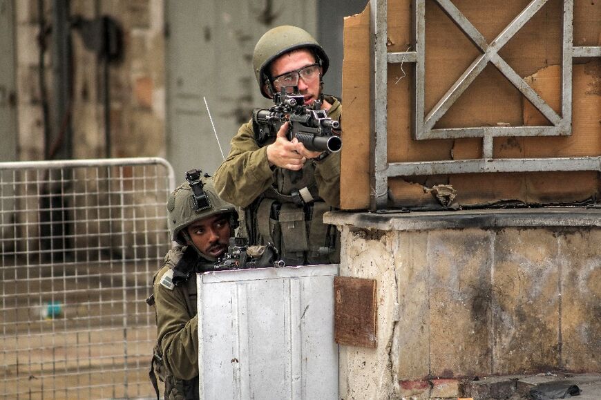 Israeli soldiers take aim during clashes in the centre of Hebron in the occupied West Bank