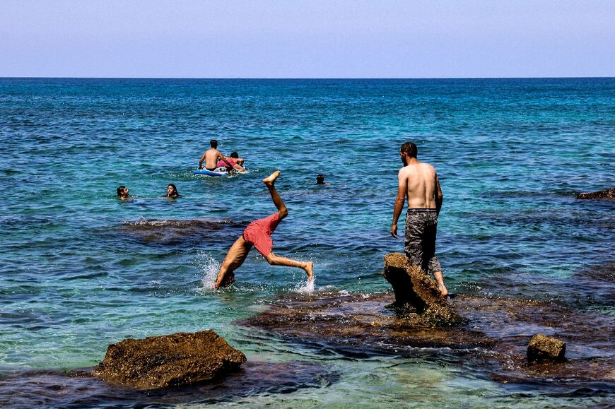 Swimmers enjoy the blue waters off the north Lebanon village of Kfarabida