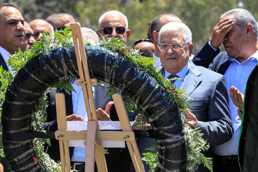 Palestinian president Mahmud Abbas recites a prayer as he lays a wreath of flowers by the graves of Palestinians killed in recent Israeli military raids on the Jenin camp