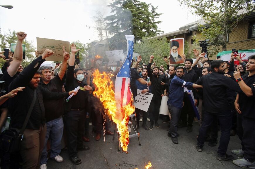Iranian students burn a US flag during a demonstration denouncing the burning in Sweden of the Koran