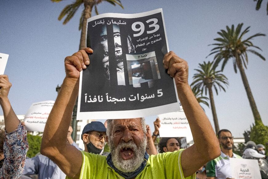 A Moroccan activist holds a banner with the image of imprisoned journalist Soulaimane Raissouni at a protest in the capital Rabat on July 10, 2021 