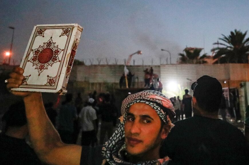 A protester holds up a copy of the Koran