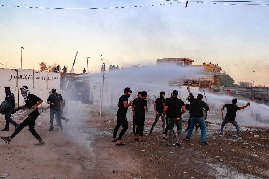 Iraqi riot police use water cannon to disperse the protesters