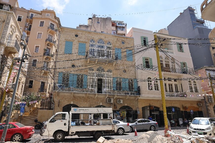 People drive past newly restored historic buildings in Beirut's Gimmayzeh district