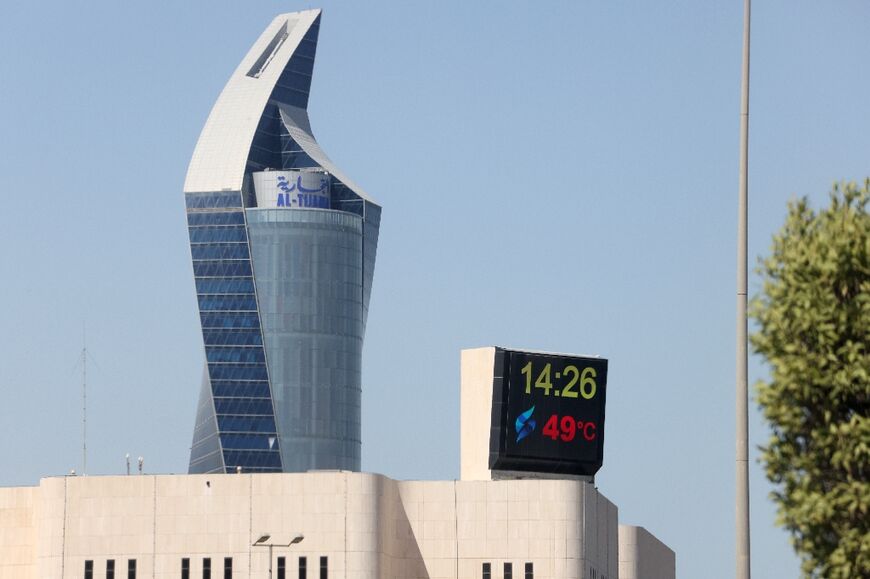 A screen displays a temperature of 49 degrees Celsius in Kuwait City on July 23, 2023