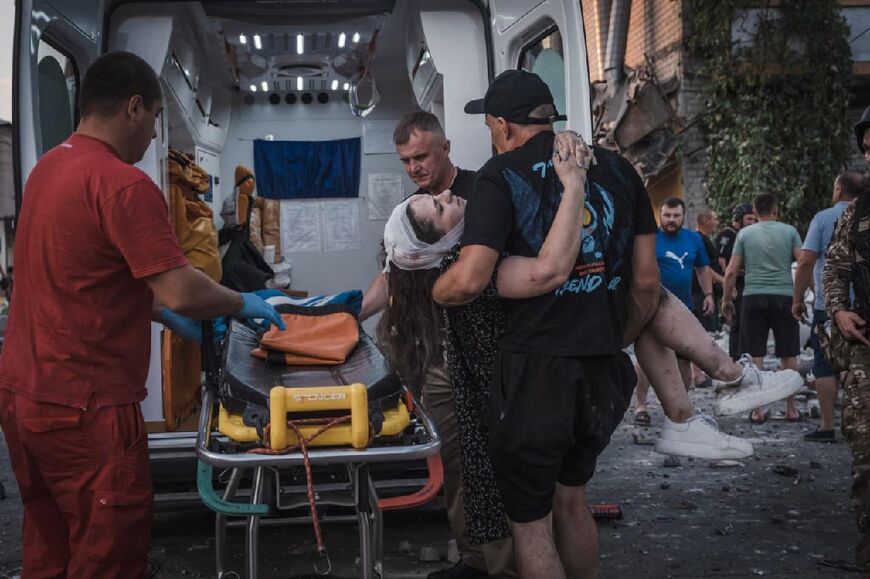 Rescuers carry a wounded woman following a Russian missiles strike in Pokrovsk, Donetsk region
