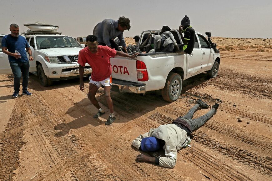 A migrant collapses from exhaustion and dehydration near Al-Assah on the border on July 30