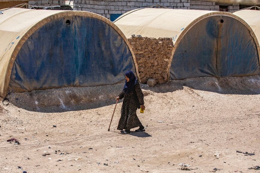 A woman walks past tents at the Al-Talaeh makeshift camp for displaced people in Syria's northeastern Hasakeh province