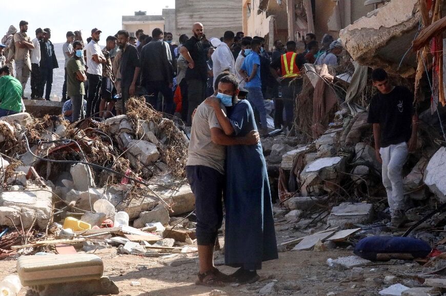 Residents search mangled buildings for missing loved ones and bulldozers clear streets of debris and mountains of sand