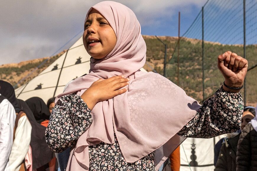 A pupil sings the Moroccan national anthem outside the makeshift school in Asni