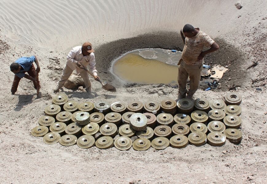 Yemeni demining experts prepare for a controlled explosion to destroy explosives and mines laid by Huthi rebels, on April 5, 2016 in the southern city of Aden