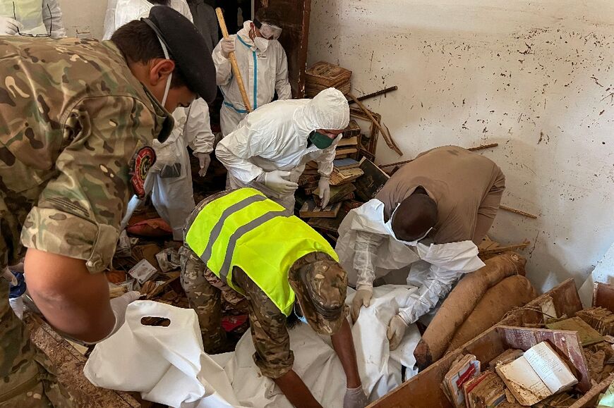 Rescue personnel recover a body from the rubble of a building in Derna in the aftermath of the devastating flood