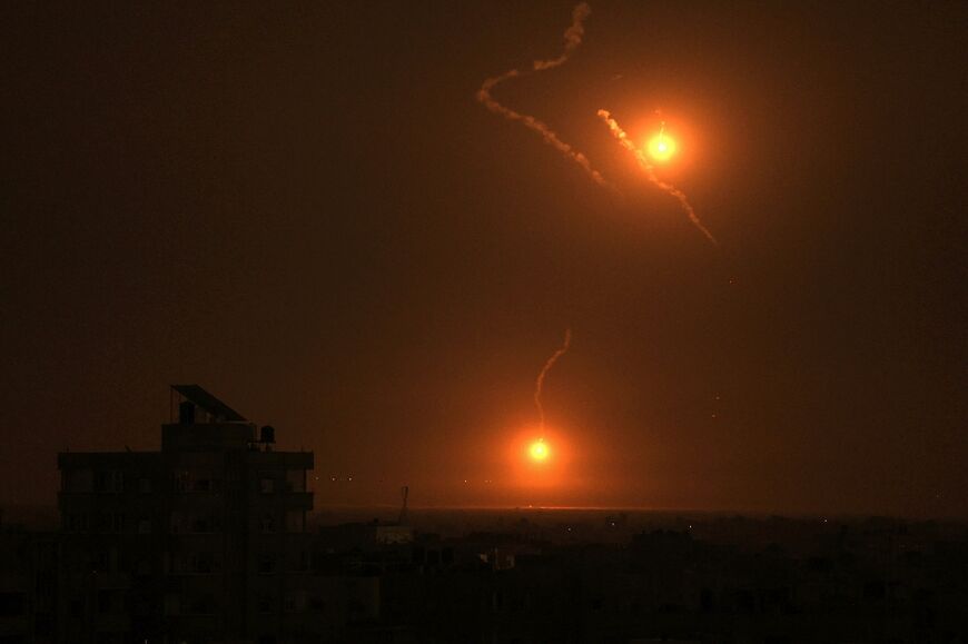 Flares fired by the Israeli army light up the night sky east of the city of Khan Yunis in the southern Gaza Strip