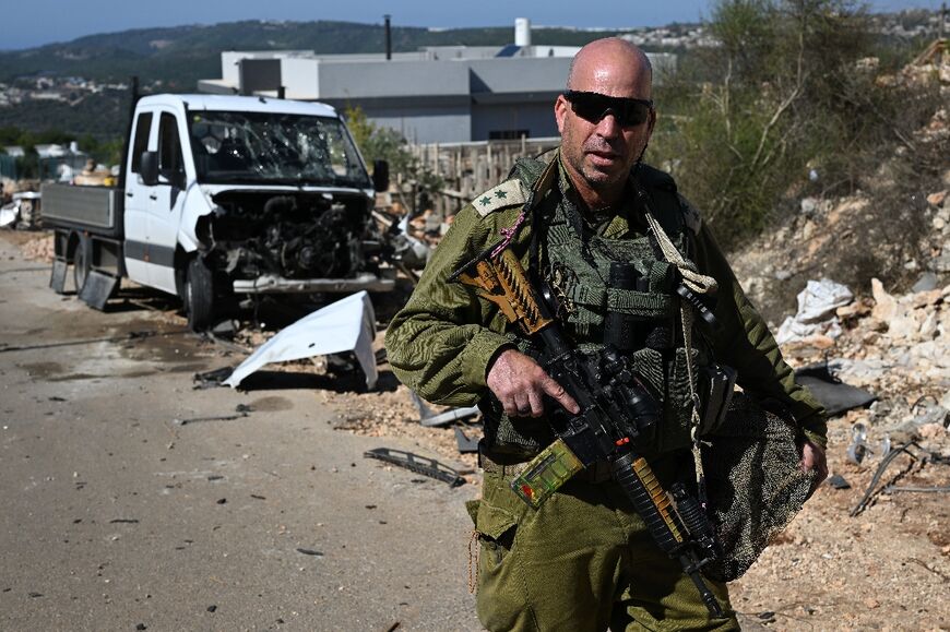 An Israeli soldier escorts journalists on a tour of the battered Lebanese border area