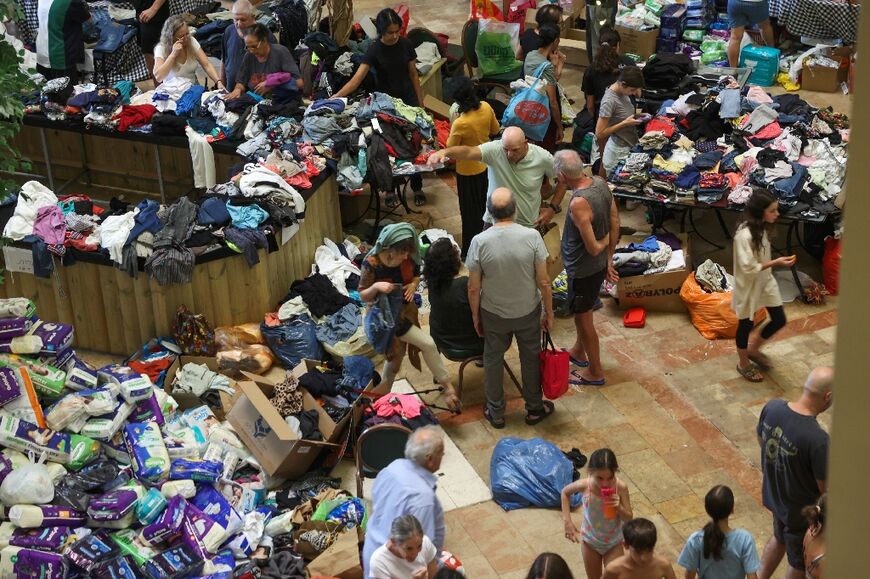 Israeli evacuees from kibbutzim near the Gaza border receive clothing donations at a hotel in the Dead Sea area