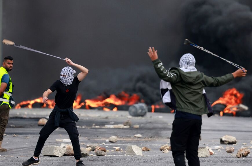 Palestinians in Ramallah on the West Bank hurl stones at Israeli forces during a demonstration against Israli bombardment of the Gaza Strip in retaliation for Hamas attacks