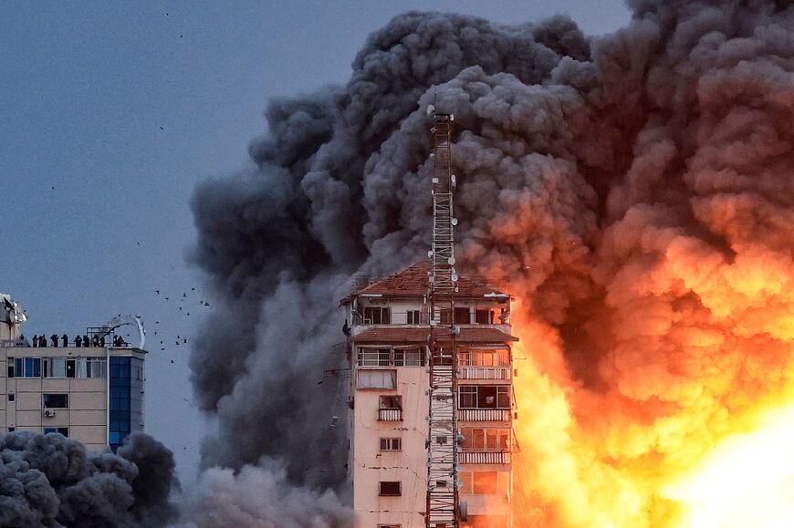 A ball of fire and smoke rises above a building in Gaza City on October 7, 2023 during an Israeli air strike 
