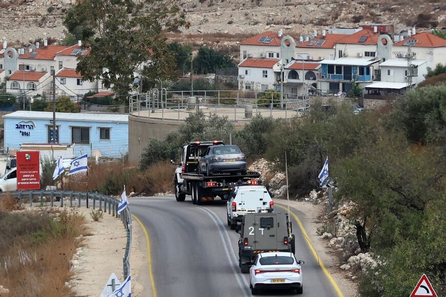 Israeli forces use a tow truck to remove a car from the scene of a reported shootout near the West Bank village of Shufa in the Tulkarm area