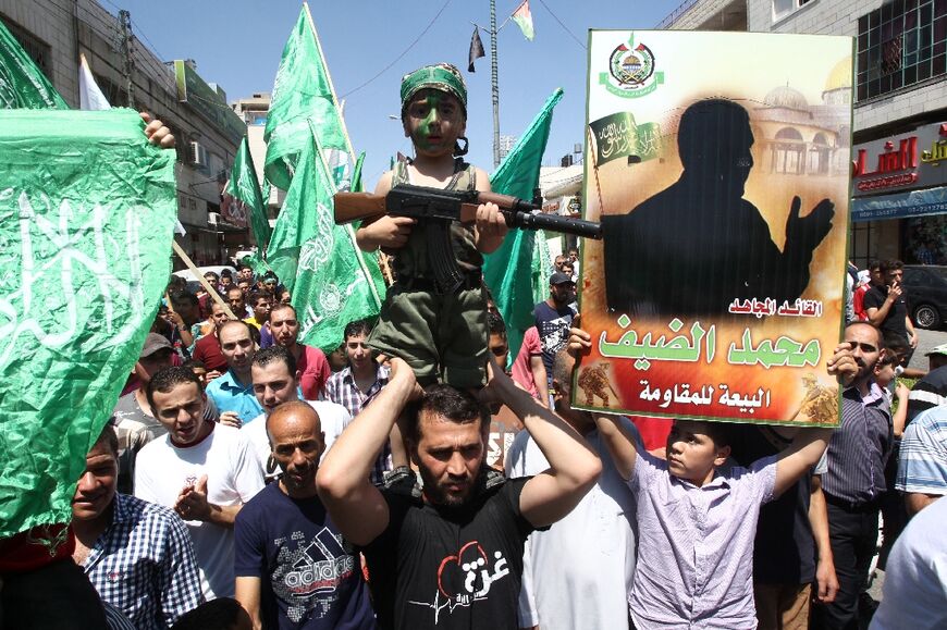 Los partidarios de Hamas en Cisjordania sostienen una silueta del esquivo jefe militar del movimiento islamista, Mohammed Deif, quien casi nunca es fotografiado después de repetidos intentos de asesinato por parte de Israel.
