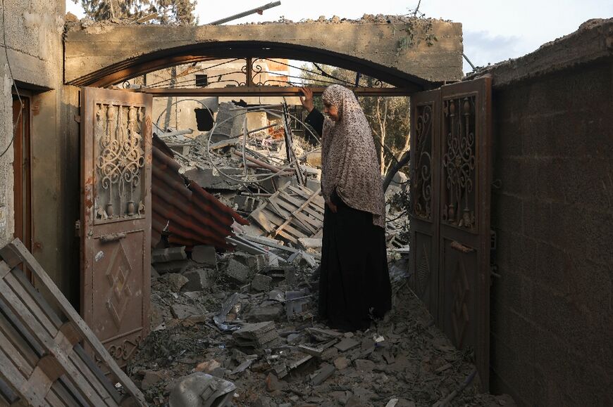 A woman inspects the damage to her home after Israeli strikes on the Rafah camp in the southern Gaza Strip