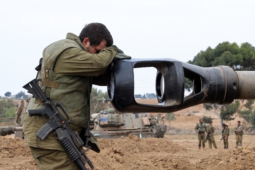 An Israeli soldier rests against an artillery gun barrel near the border with Gaza, where Palestinians braced for what many feared will be a massive Israeli ground attack