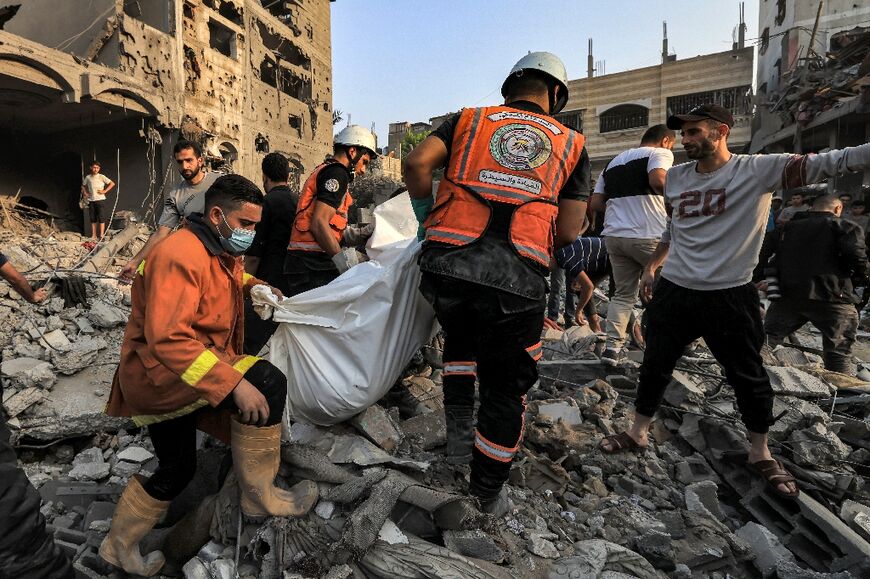 Palestinian rescuers carry the body of a victim out of the rubble of a building hit by an Israeli strike in the southern Gaza town of Khan Yunis 