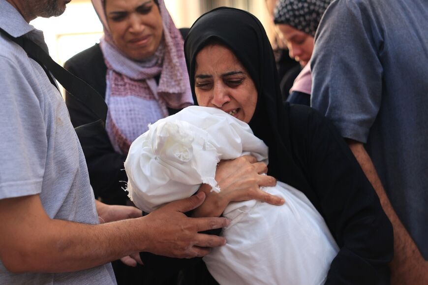 Relatives carry the body of 8-month-old Ahmed Barhom at the funeral for members of the same family killed in Israeli bombardment, in Rafah in the southern Gaza Strip on November 6, 2023