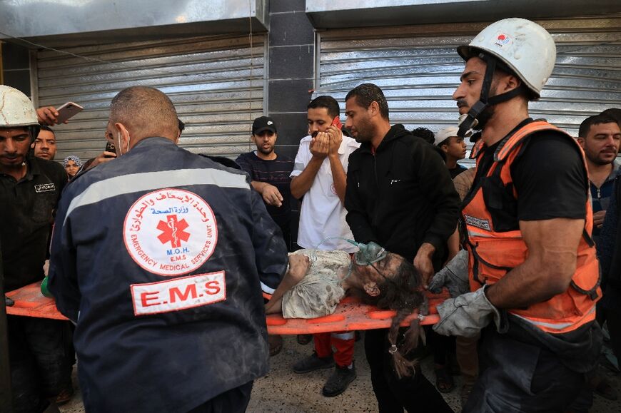 Palestinian rescuers carry a victim of bombardment in Khan Yunis