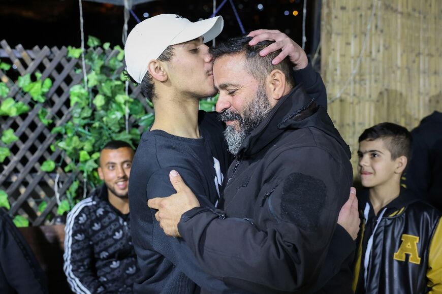 Palestinian Mohammed al-Awar (L), a former prisoner released from an Israeli jail in exchange for hostages freed by Hamas in Gaza, kisses his father's forehead upon return to his home in east Jerusalem